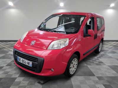 La petite camionnette rouge est garée dans une grande pièce.