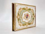a white and gold box with a floral design on it