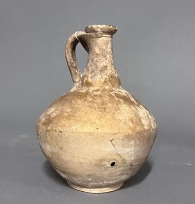 un vase marron posé sur une surface grise