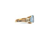 a close up of a gold ring with a blue topaz stone