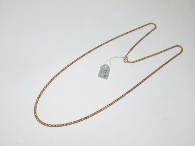 une chaîne en or à laquelle est accrochée une étiquette, posée sur une surface blanche
