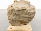 a large rock sitting on top of a small cart