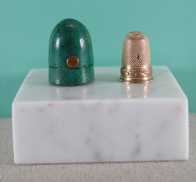 deux dés à coudre posés sur un bloc de marbre