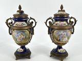 deux vases bleus ornés d'une bordure dorée et d'une peinture