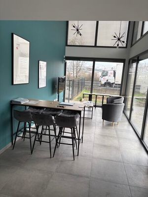 une pièce dans laquelle se trouvent une table, des chaises et une télévision