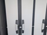 three white refrigerators in a row in a public restroom
