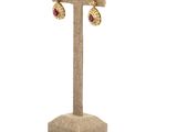 a close up of a pair of earrings on a stand
