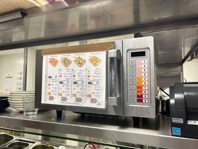 une photo de la cuisine d'un restaurant avec un menu accroché au mur