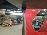 a red sheet covering the underside of a boat in a warehouse