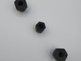 four black hexagonal nuts on a white surface with a white background