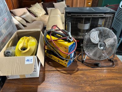 a box of air conditioners and a fan on a coffee table