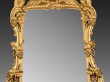 un miroir richement sculpté, orné d'un motif représentant des oiseaux et des fleurs