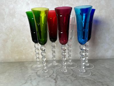 quatre verres à vin de couleurs différentes posés sur une table