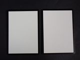 deux feuilles de papier blanc posées l'une à côté de l'autre sur une surface noire