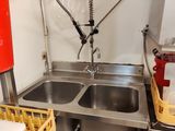 une cuisine avec un évier dans lequel se trouve un seau rouge
