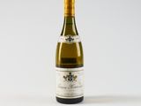 a bottle of white wine sitting on top of a white table