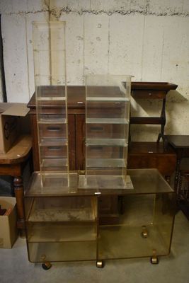 une table en verre surmontée d'une étagère en verre