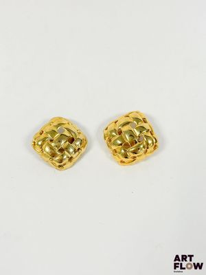 une paire de boucles d'oreilles plaquées or sur fond blanc