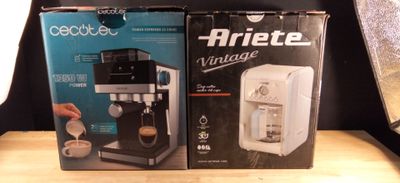 two boxes of coffee machines sitting on top of a wooden table