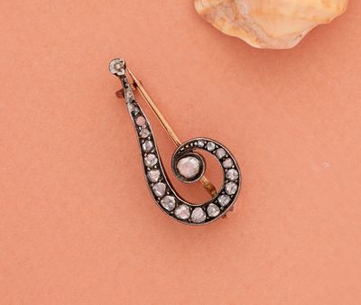 un gros plan d'une broche ornée d'une perle et d'un diamant