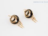 pair of black and gold earrings with pearls on them