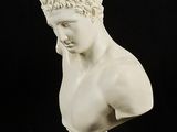 marble bust of a man with curly hair on a black background