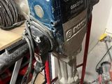 a drill that is sitting on a stand in a garage
