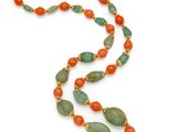a close up of a long necklace with green and orange beads