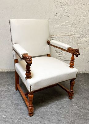 une chaise blanche ornée d'une tête de lion