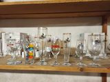 des bouteilles et des verres posés sur une étagère dans une pièce dotée d'une étagère en bois