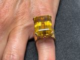la main d'une femme à laquelle est passée une bague jaune