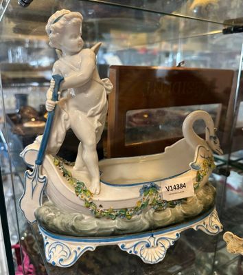 une figurine représentant un garçon dans un bateau, exposée dans une vitrine