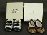 two pairs of baby shoes are sitting next to a box