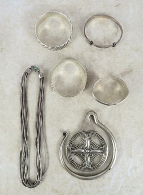 Plusieurs objets en argent sont disposés sur une surface blanche