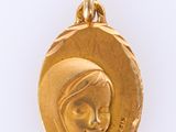 a close up of a gold medal with a woman ' s face on it
