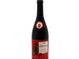 a bottle of red wine sitting on top of a white table