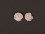 a pair of silver coins on a black surface