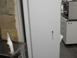 un réfrigérateur blanc posé dans une cuisine, à côté d'une table