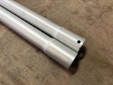two metal tubes are laying on a wooden surface