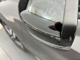 a dog sticking its head out of a car ' s side view mirror