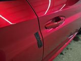 a close up of a red car door with a sticker on it