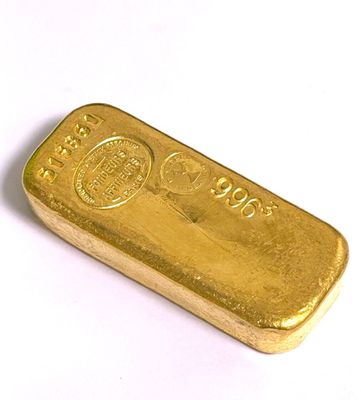 une barre d'or posée sur une surface blanche