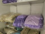 many pillows and blankets on the shelves in the closet