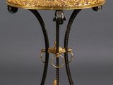an ornately decorated table with a gold top and black legs