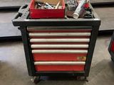 une boîte à outils rouge sur laquelle sont posés des outils, dans un garage