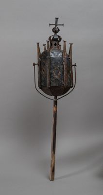 a small metal tower with a cross on top of it