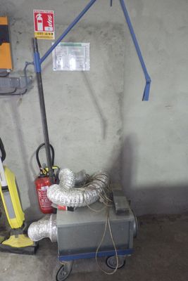 une machine qui est garée dans un garage, avec un tuyau d'arrosage