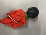 a red cloth and a black plastic object on a white surface