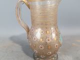 a glass pitcher sitting on a table next to a gray wall