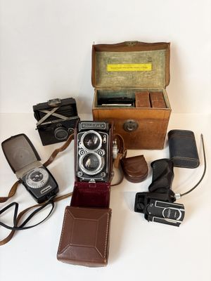 de nombreux modèles différents d'appareils photo anciens posés sur la table
